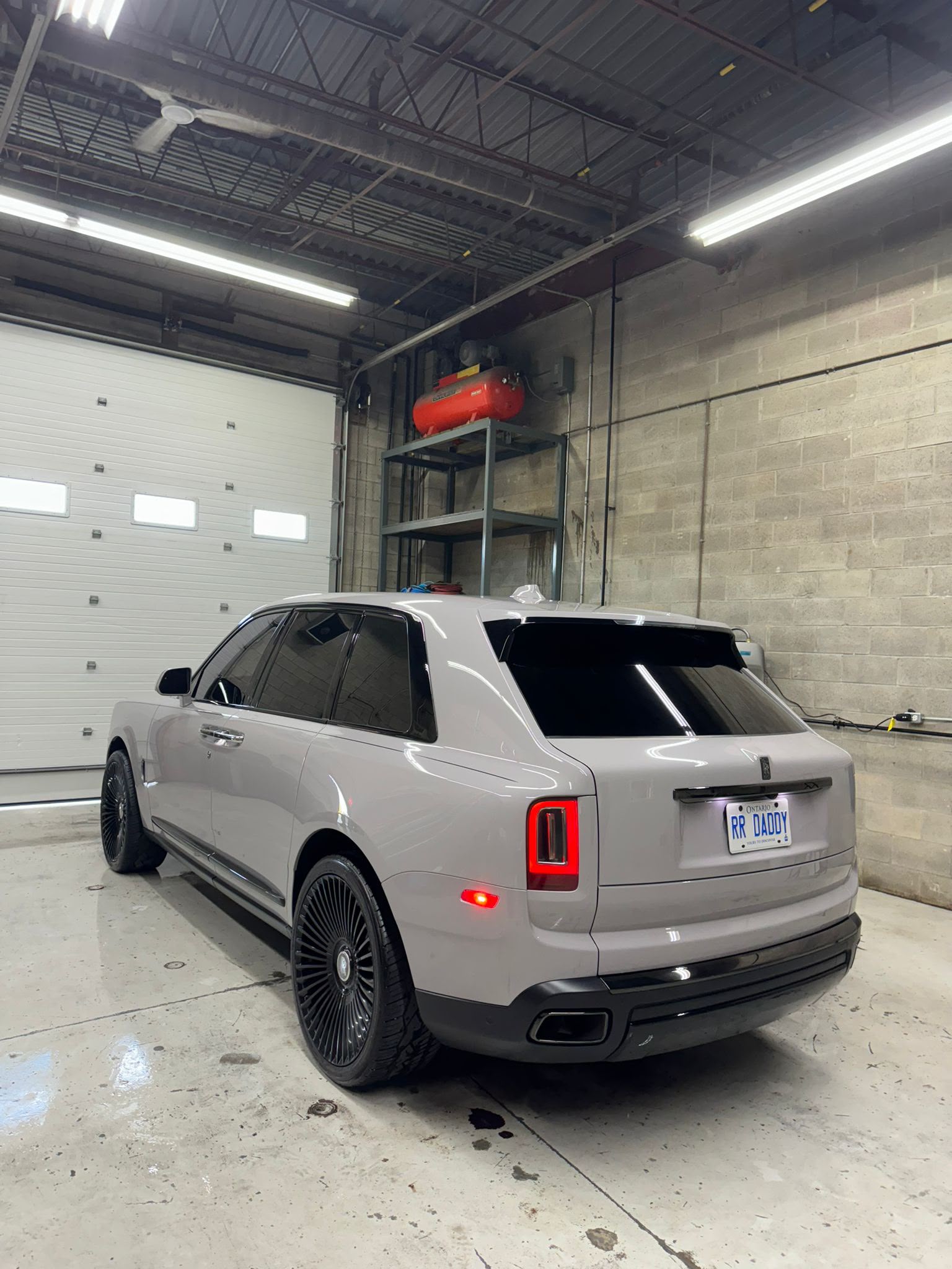 Rolls-Royce Cullinan — Rear 3/4 Stance Under Bay Floodlights